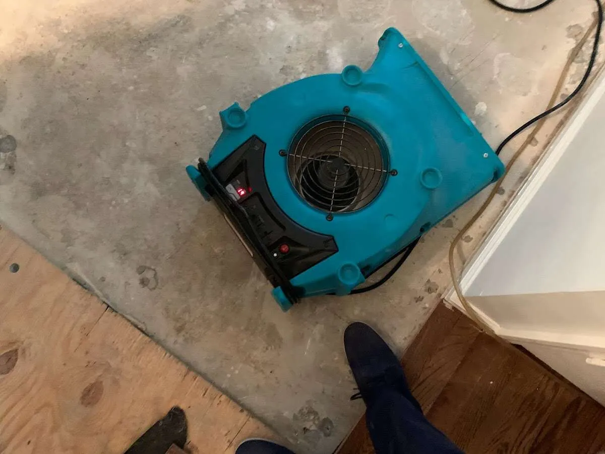 Air mover drying subfloor during Commercial Water Damage Restoration in Progress Village